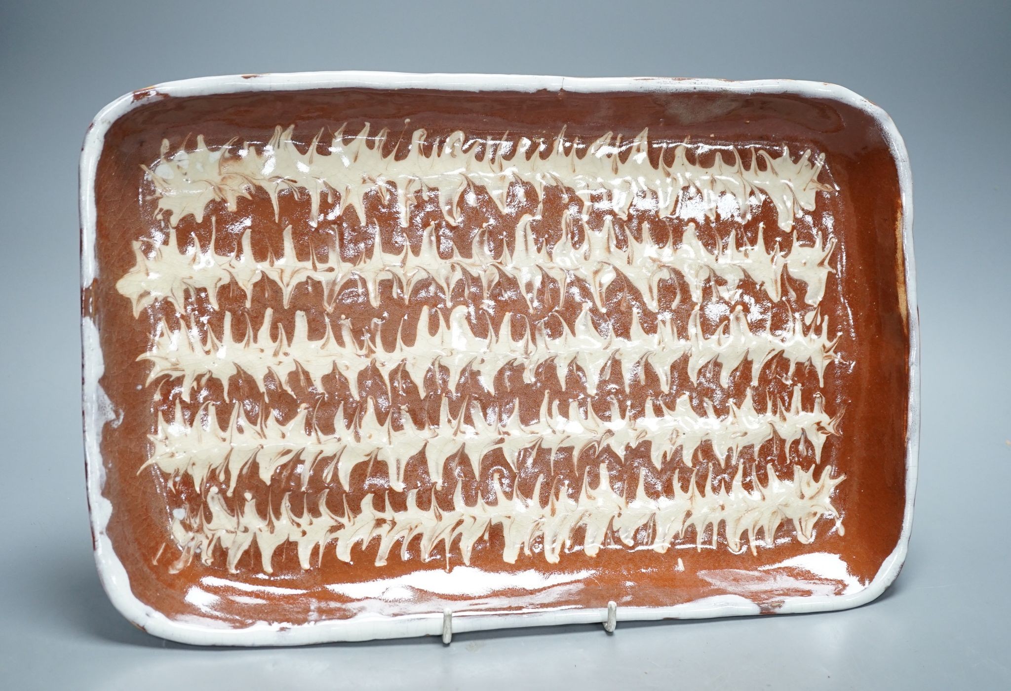 A slipware baking dish, indistinctly signed Findlay Fri(?), 37.5 cms wide.